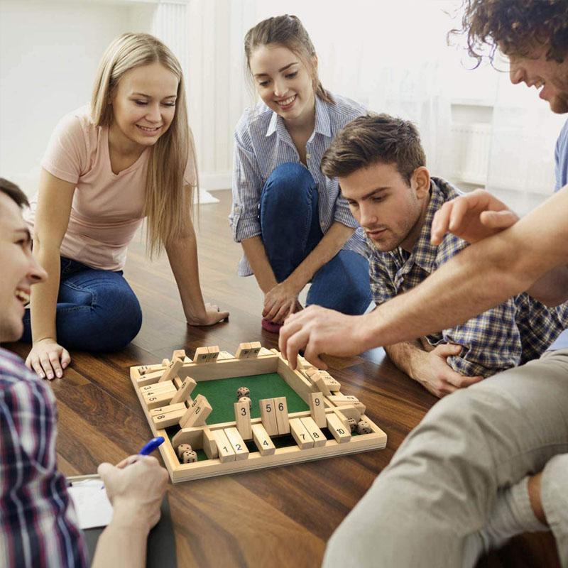 Kids and adults playing Shut The Box, a wooden dice game that's an engaging educational toy