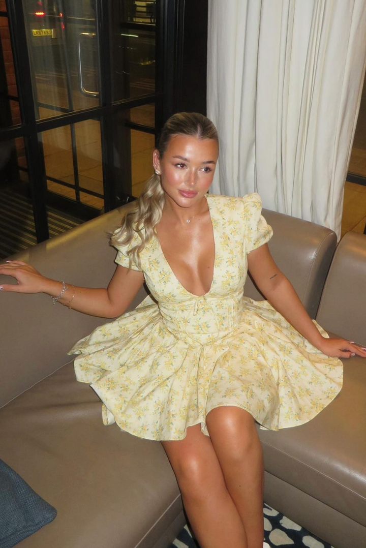 Vibrant yellow floral mini dress, A-line fit, puff sleeves, and a flattering open back.